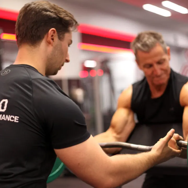 Julian Ernst coaching a client through a strength exercise